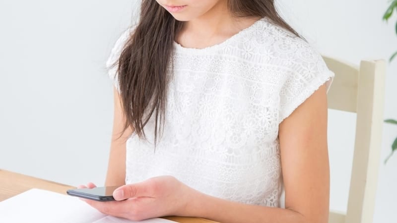 スマートフォンで授業を受けている生徒の画像